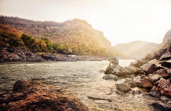 A guest relaxing on the banks of the river after rafting