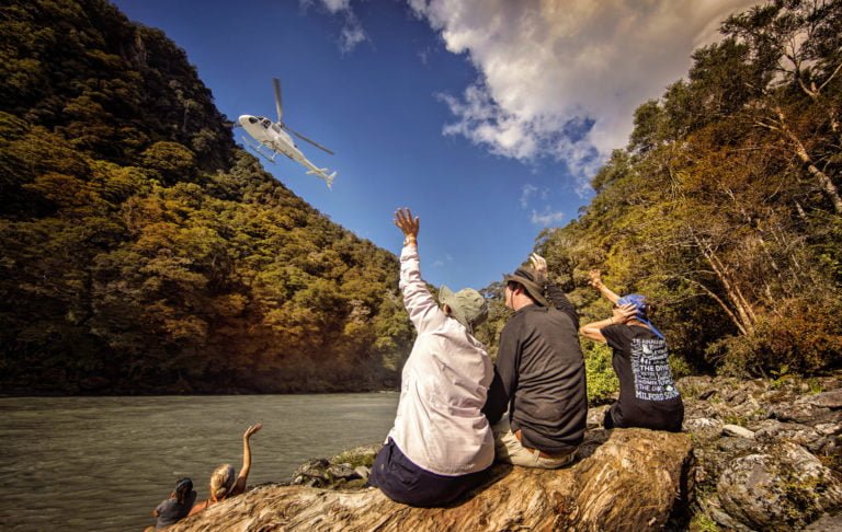 Clients waving to helicopter as it leaves river on New Zealands South Island