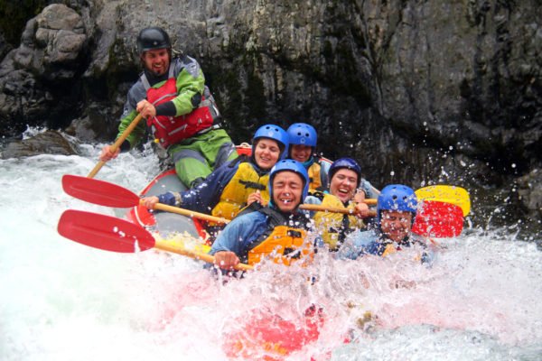 A crew holding on in an orange raft in New Zealand