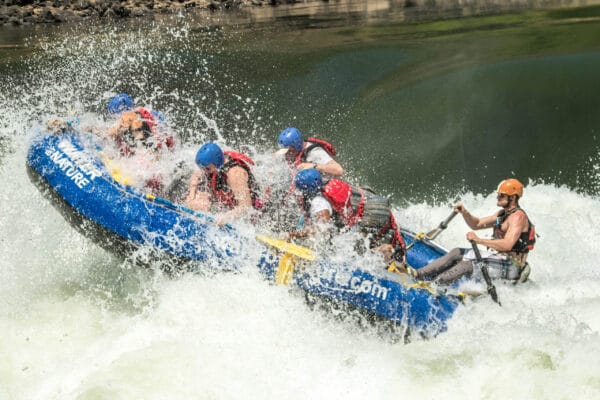 Guide in blue raft running clients through Creamy White Buttocks on Zambezi